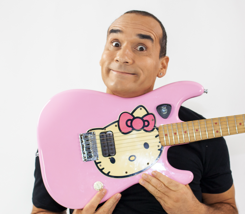 Jaimão no palco a tocar guitarra com expressão humorística
