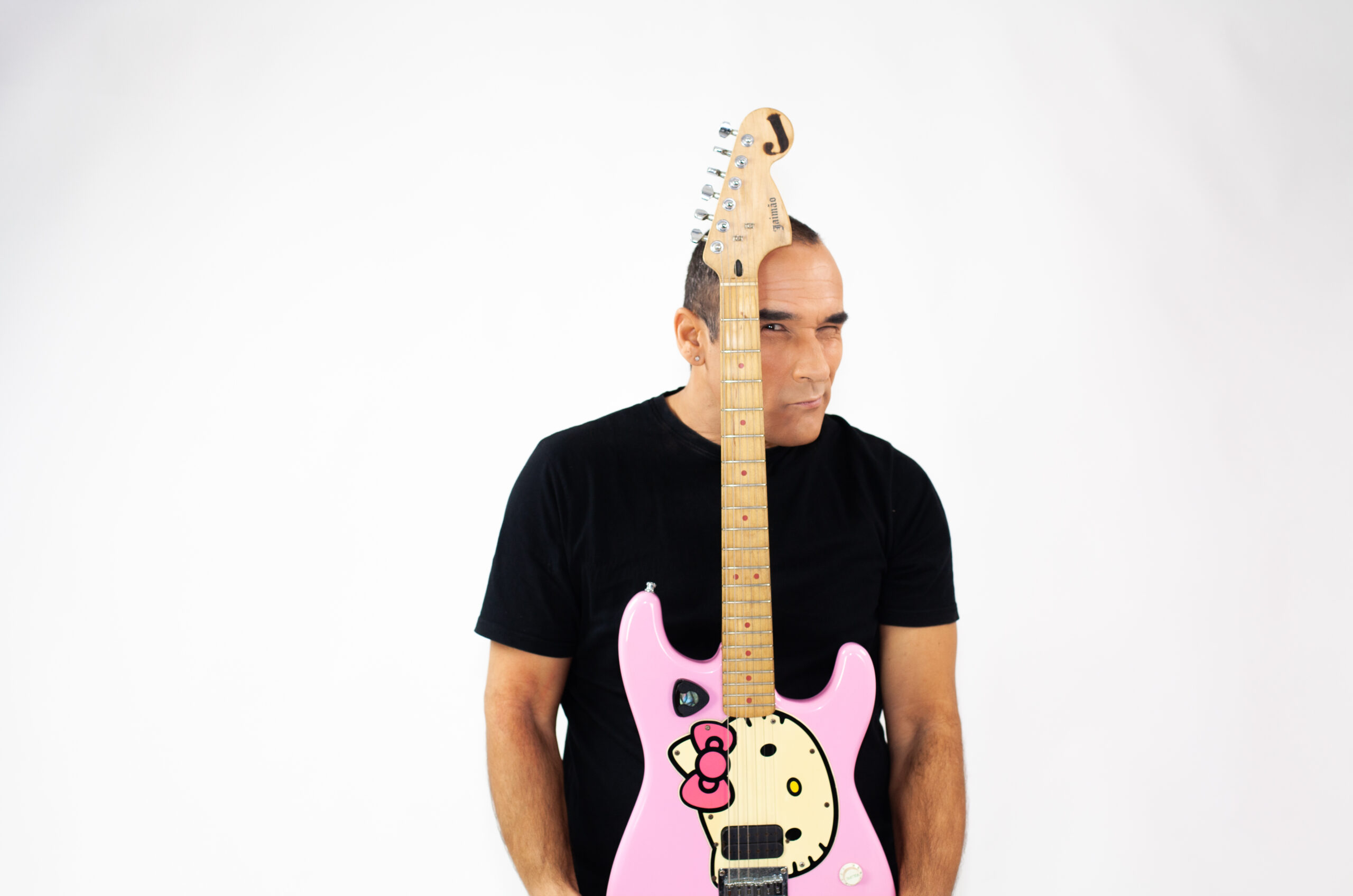 Jaimão no palco com iluminação cénica dramática e guitarra característica